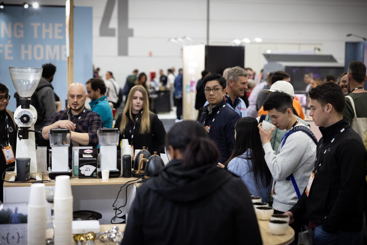 grupo de homens e mulheres em estande da Nucoffee em feira internacional de café
